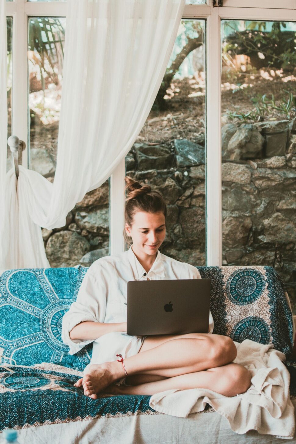 https://www.pexels.com/photo/smiling-woman-using-macbook-while-sitting-on-sofa-1546329/