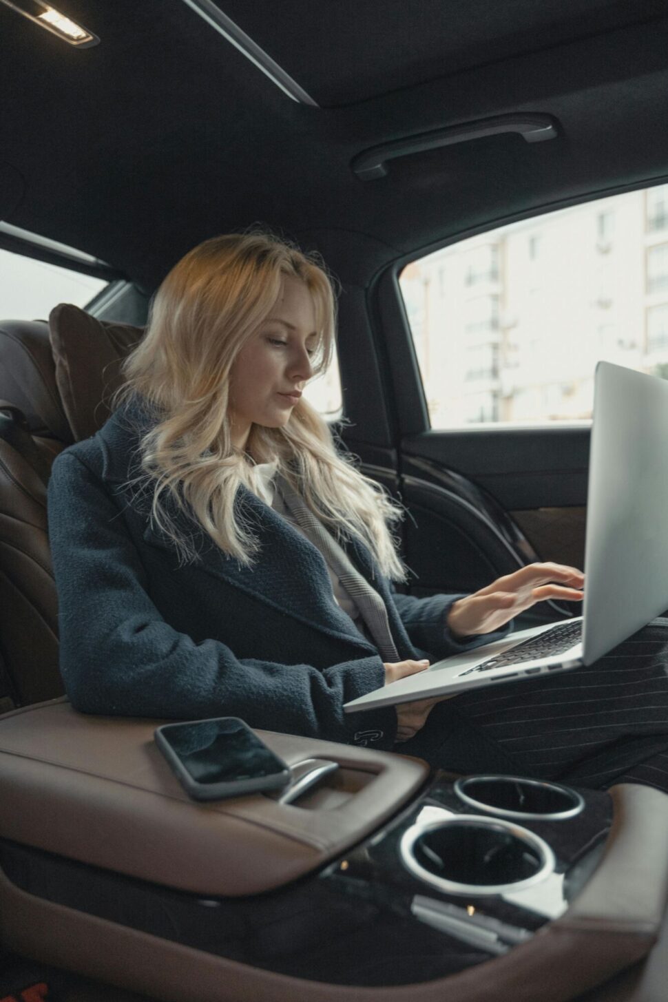 https://www.pexels.com/photo/woman-in-gray-business-suit-sitting-at-the-back-seat-of-a-luxurious-car-5717642/