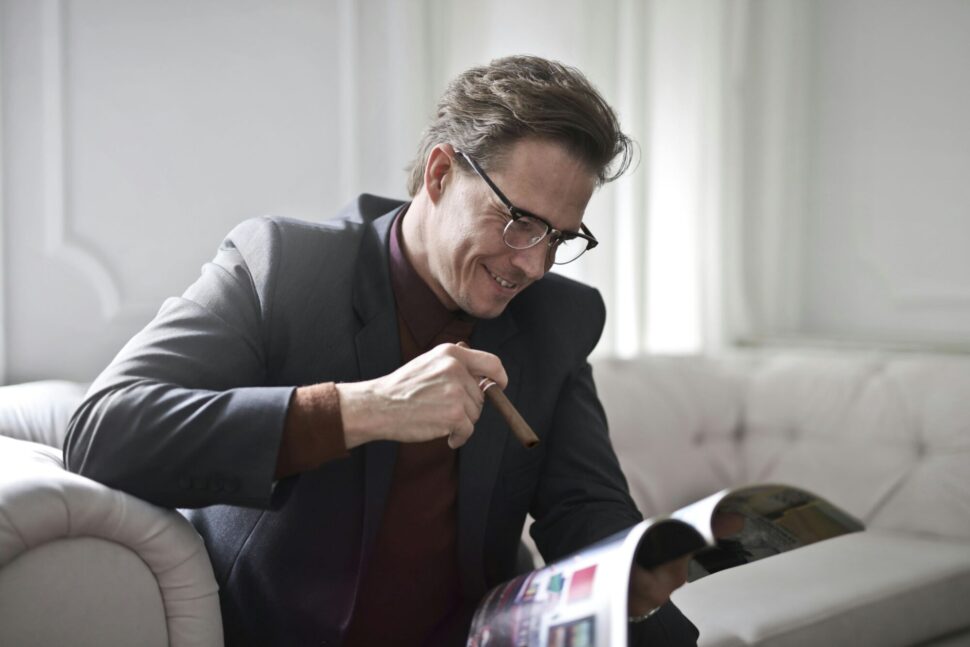 https://www.pexels.com/photo/elegant-businessman-with-cigar-reading-magazine-at-home-3771100/